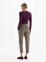 Pantalón de vestir color gris, de corte regular y largo tobillero. Presenta cintura alta con trabillas, cierre frontal con doble gancho y un cinturón desmontable con hebilla metálica.