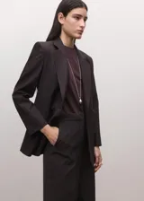 Pantalón de sastre color marrón oscuro, de corte recto y tiro medio, con bolsillos laterales y raya central marcada.