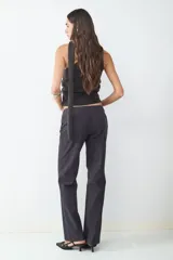 Pantalón de vestir de corte recto y tiro bajo, confeccionado en tela con estampado de rayas diplomáticas. Presenta cierre frontal con cremallera y diseño estructurado.