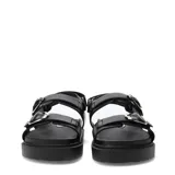Sandalias de plataforma plana Miss Carol modelo Naira, color negro con doble tira ajustable con hebillas metálicas plateadas y suela dentada.