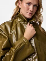 Campera corta de estilo moderno con acabado engomado brillante, cuello camisero, cierre frontal con botones a presión ocultos y bolsillos laterales.