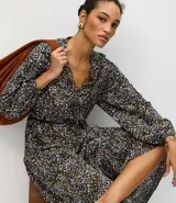 Vestido midi de corte fluido con estampado floral, escote en V con cordones ajustables, mangas largas abullonadas y falda con volados en el ruedo.