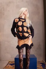 Sweater de diseño artesanal que combina círculos de cuero agamuzado unidos mediante tejido a crochet de lana merino. Presenta cuello a la base, mangas largas con puños y un calce holgado.