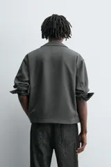 Sobrecamisa regular fit color gris oscuro, confeccionada en tejido con viscosa. Presenta cuello solapa, manga larga con puño abotonado, bolsillos de vivo en la cadera y cierre frontal con cremallera.