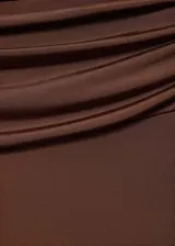Pantalon de tiro bajo color marrón, con diseño acampanado y detalle drapeado en la cintura. Confeccionado en tejido fluido de punto circular.