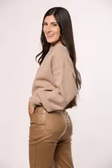 Pantalon chupin de ecocuero negro, de tiro alto con cierre y botón frontal, y bolsillos laterales.