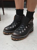 Borcego de cuero negro con cordones y suela track color caramelo.