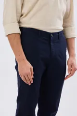 Pantalón de lino color beige, de corte recto y cintura elastizada con presillas para cinturón y bolsillos laterales.