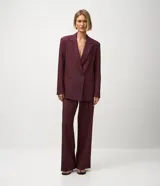 Blazer femenino color bordó, de corte oversized y caída recta. Presenta cierre traspasado con dos botones delanteros, mangas largas, cuello con solapa tradicional y bolsillos delanteros con acabado incorporado. Cuenta con forro interno.
