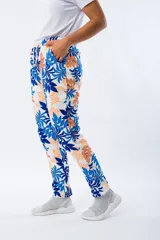 Pantalón babucha blanco con estampado de hojas en azul y naranja, con cintura elástica y cordón ajustable.