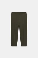 Pantalón de vestir color marrón oscuro, tiro alto, corte recto o ligeramente cropped, con pinzas frontales y bolsillos laterales.