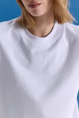 Remera básica de jersey de algodón, con cuello redondo a la base y mangas cortas. Presenta un isologo de la marca bordado a tono en el centro del pecho.