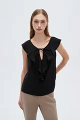 Blusa negra de viscosa sin mangas, con cuello redondo, volados frontales y detalle de lazo en el escote.