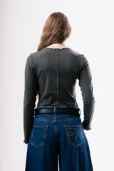 Camiseta de manga larga en color gris oscuro, con cuello redondo y costuras decorativas expuestas en el frente. Presenta un diseño ajustado al cuerpo.