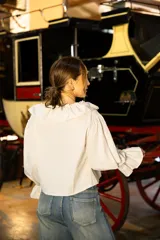 Blusa de algodón con estampado a cuadros vichy en tonos beige y blanco. Presenta un diseño con volados en el escote, mangas largas amplias y puños con volados.