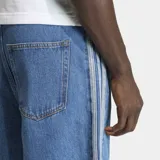 Short de jean estilo bermuda de corte holgado, color azul medio. Presenta las icónicas tres rayas laterales de Adidas en tono más claro y cierre de botón frontal. Incluye bolsillos delanteros y traseros.