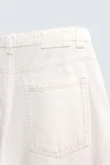 Jeans de denim de algodón color negro, con corte balloon fit relajado desde la cadera y ligeramente estrechado en el bajo. Tiro medio, cinco bolsillos y cierre frontal con cremallera y botón.