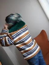 Buzo canguro oversize con capucha y cuello alto, confeccionado con paños de lana estampados.