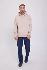 Hoodie color beige de manga larga con capucha, corte relajado, interior afelpado, bolsillo canguro frontal y estampado en la espalda. Confeccionado en tejido circular con reverso cepillado.