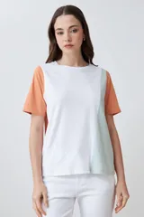 Remera de manga corta con diseño color block, combinando paneles en color blanco, naranja y verde agua.
