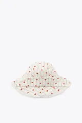Gorro tipo bucket de algodón, color crudo, con rayas verticales finas en tono neutro y pequeños corazones rojos bordados distribuidos por toda la superficie. Presenta ala ancha con terminación deshilachada.