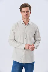 Camisa de lino rayada de manga larga, con cuello camisero, cierre frontal de botones y bordado sutil en el pecho.