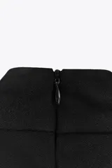 Top negro de cuello halter con cierre de botones en la parte trasera del cuello y espalda descubierta.