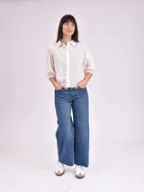 Camisa blanca de mangas 3/4 con detalles de calado en los hombros.