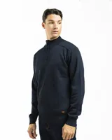 Sweater de punto color azul marino con cuello alto y medio cierre metálico frontal. Presenta detalles de tejido acanalado en los hombros y cuello, con puños y cintura elastizados.