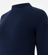Suéter de tricot color amarillo claro, de manga larga y cuello redondo. Presenta detalles de volados acanalados en el ruedo y en los puños.