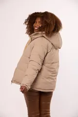 Campera reversible para mujer con diseño acolchado de nylon en un lado y corderito sintético en el otro. Cuenta con capucha, cierre frontal y mangas largas.