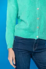 Cardigan tejido color verde agua, con cuello redondo, cierre frontal con botones y mangas largas.