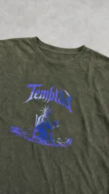 Remera oversize de algodón con acabado stone wash en color verde. Presenta un estampado frontal en serigrafía con tipografía gótica y una figura central con halo solar.