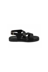 Sandalias planas de cuero color negro, con tiras cruzadas en el empeine, diseño abierto y tira en el talón con hebilla metálica dorada para ajuste.