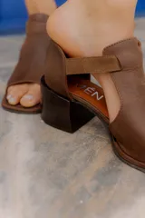 Sandalias de cuero color suela, con taco ancho de altura media, puntera abierta cuadrada y tira ancha en el empeine. Cuentan con tira trasera ajustable con hebilla.