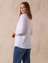 Blusa amarilla de manga 3/4 con escote en V y bordado multicolor. Largo de manga regulable con presilla y botón. Marca Ruby Rd.