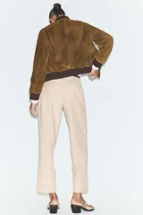 Pantalón tobillero de corte recto en color beige, con detalle de nervio delantero marcado. Incluye cinturón fino, bolsillos delanteros y cierre frontal con cremallera, botón interior y gancho.