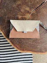 Sobre de cuero nude con solapa de cuero texturizado color crema y pulsera desmontable con estampado animal print.