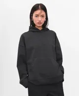 Hoodie de corte oversize color gris oscuro, con capucha ajustable, bolsillo estilo canguro en el frente, mangas largas y puños y ruedo elásticos acanalados.