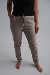 Pantalón de corte recto y ajuste cómodo, color beige, con cintura elástica y cordón de ajuste frontal. Cuenta con bolsillos laterales.