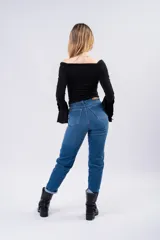 Jean mom de tiro alto con corte recto, confeccionado en denim azul clásico. Presenta cierre frontal con botón y bolsillos laterales y traseros.