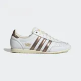 Championes Adidas modelo Japan confeccionados en cuero blanco con detalles metálicos en color bronce en las tres tiras laterales y el talón. Poseen un diseño de perfil bajo inspirado en los años 60, con puntera reforzada de doble costura, cierre de cordones y suela de caucho delgada.