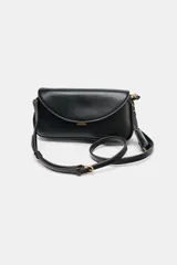 Bolso bandolera de formato alargado en color negro, con solapa frontal y cierre metálico. Incluye una correa ajustable de tejido en color crudo y herrajes dorados.