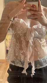 Top camisola color beige con lentejuelas bordadas, tirantes finos, volados y lazo frontal.