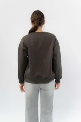 Buzo gris melange de algodón con felpa suave por dentro, cuello redondo y puños ajustados. Estampa frontal de arcoíris con rayo al centro.