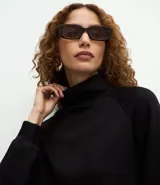 Buzo de cuello alto estructurado, confeccionado en tejido modal acanalado color marrón. Presenta un corte regular, mangas largas con puños ajustados y diseño minimalista.