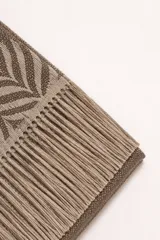 Bufanda de tejido suave con diseño de patrón geométrico en tonos marrón y beige, con terminación de flecos en los extremos.