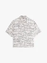 Camisa de manga corta Tommy Hilfiger de corte amplio y hombros ligeramente caídos, confeccionada en puro lino blanco con estampado geométrico de líneas azules. Cuenta con cuello inglés, cierre frontal de botones, bolsillo de parche en el pecho y logo bordado.