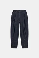 Pantalón de denim azul oscuro, tiro alto, con pinzas delanteras que generan volumen en la cadera y pernera ancha y recta. Presenta cierre frontal y bolsillos laterales.