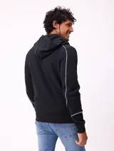 Canguro gris con capucha, cierre frontal completo y bolsillos tipo canguro. Presenta detalles de líneas blancas en las mangas y estampados gráficos en el pecho.